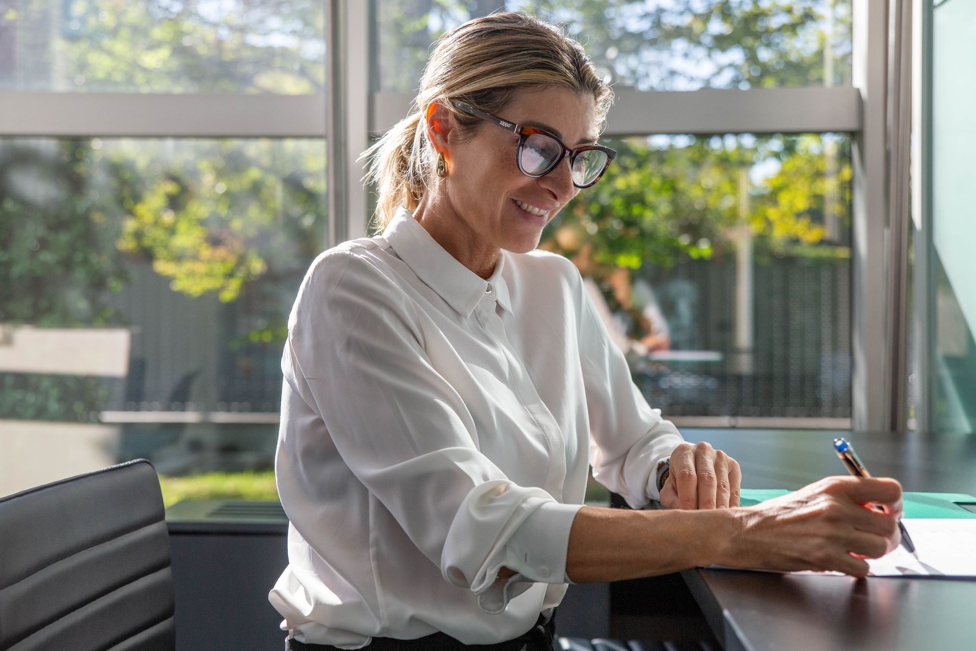 Annalisa Carnovali alla scrivania, sorridente mentre lavora su una pratica